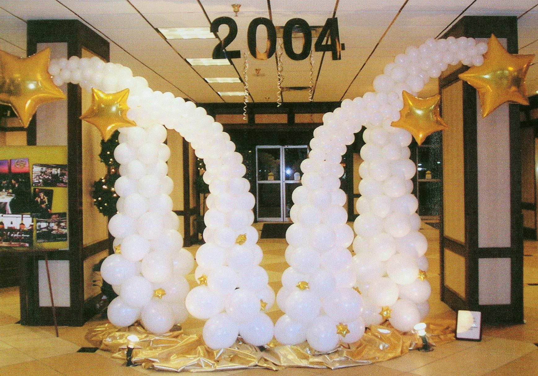 A room decorated with balloons and the year 2004
