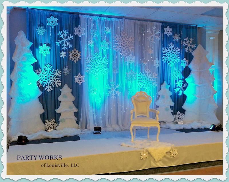 A stage decorated with snowflakes and trees and a chair