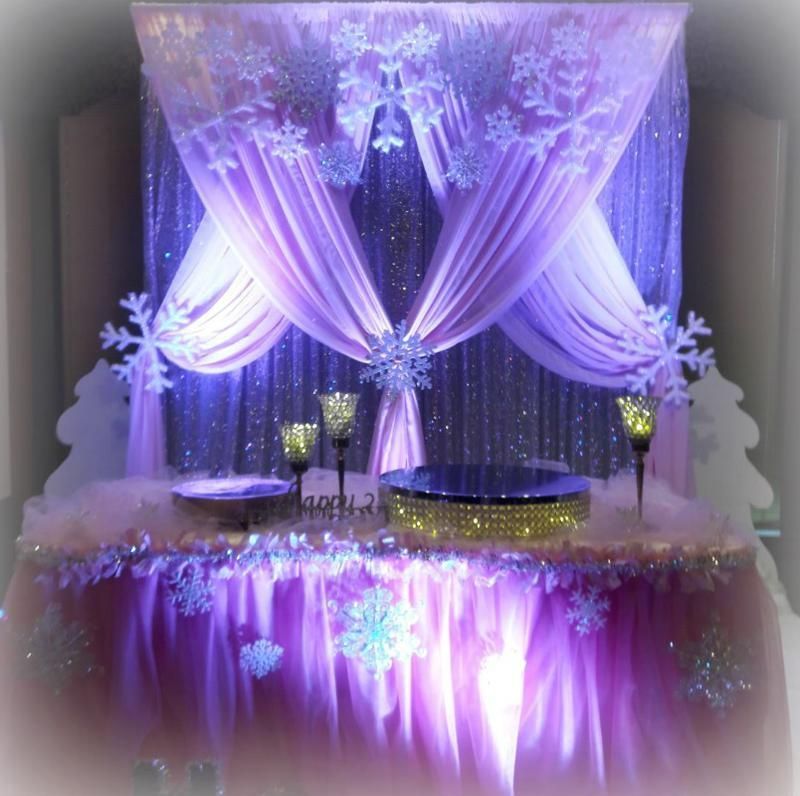 A table with purple curtains and snowflakes on it