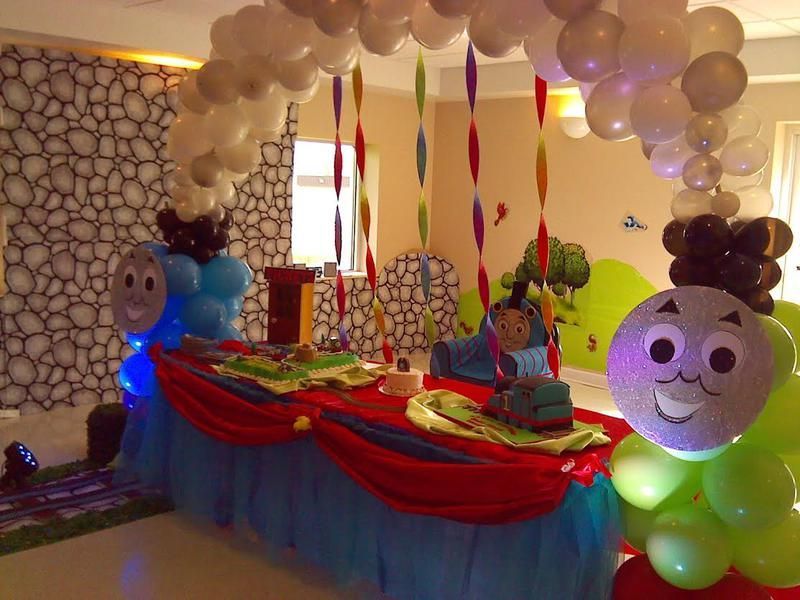 A room decorated with balloons and thomas the train balloons