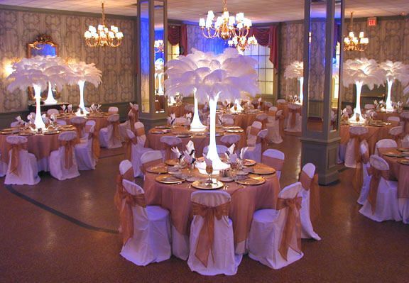 A large room with tables and chairs set up for a wedding reception