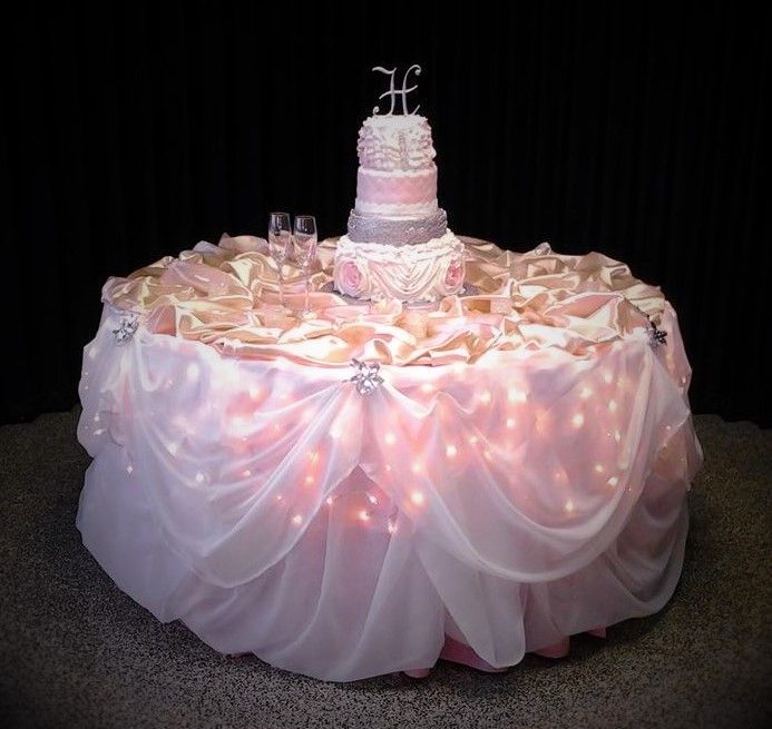 A cake on a table with a topper that says he