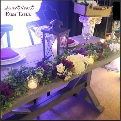 A sweetheart farm table with flowers and candles on it