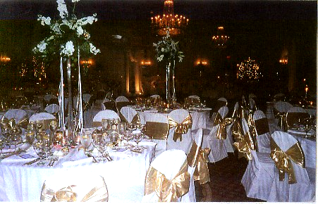 A room with tables and chairs set up for a wedding reception