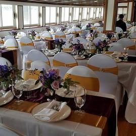 A large room with tables and chairs set up for a wedding reception.