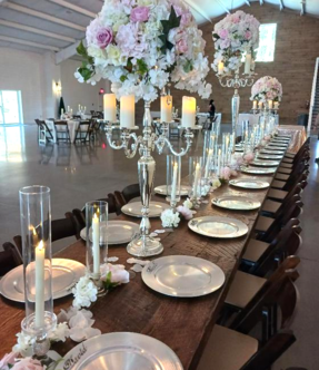A long table with plates candles and flowers on it