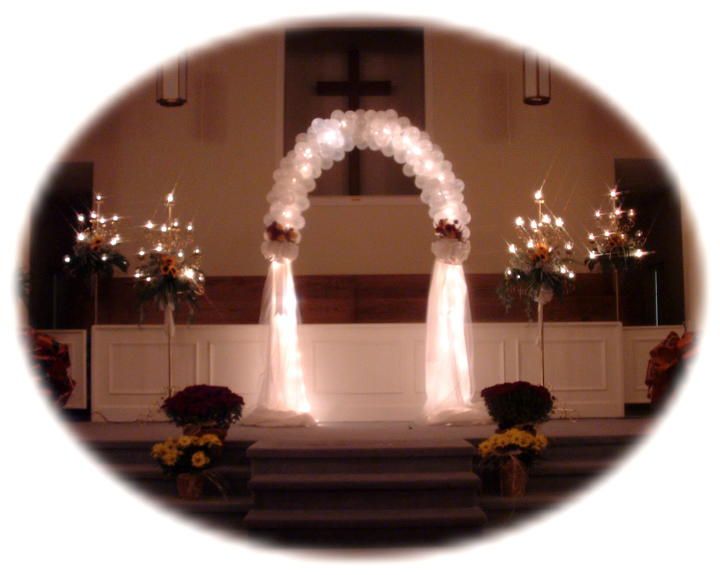 A church with a balloon arch and candles