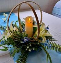 A candle is surrounded by flowers on a table