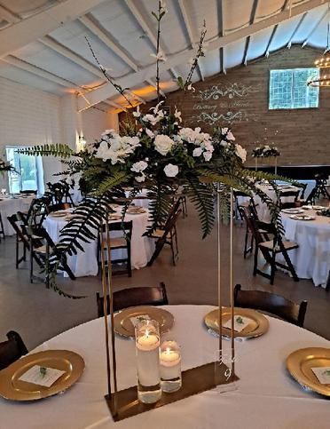 A table with a vase of flowers and candles on it.