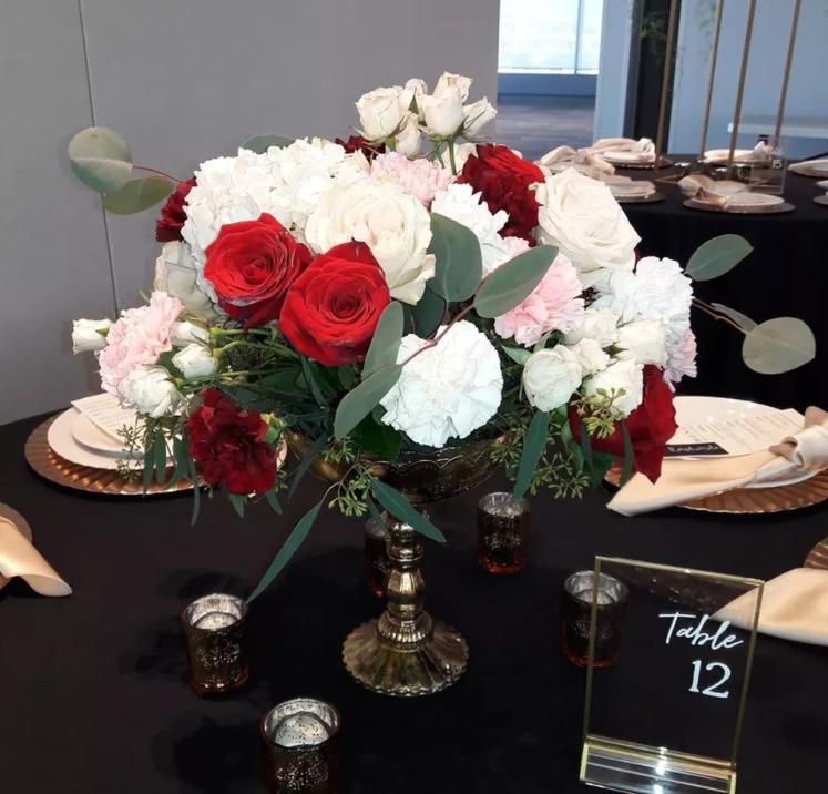 A table with a vase of flowers and a table number 12