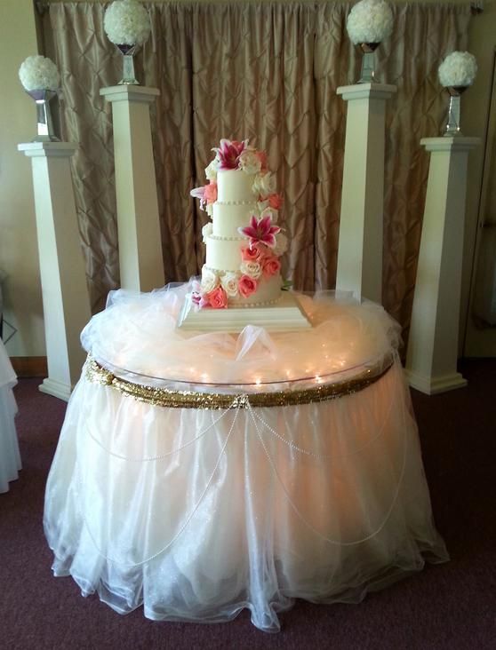A wedding cake is sitting on a table with a white table cloth