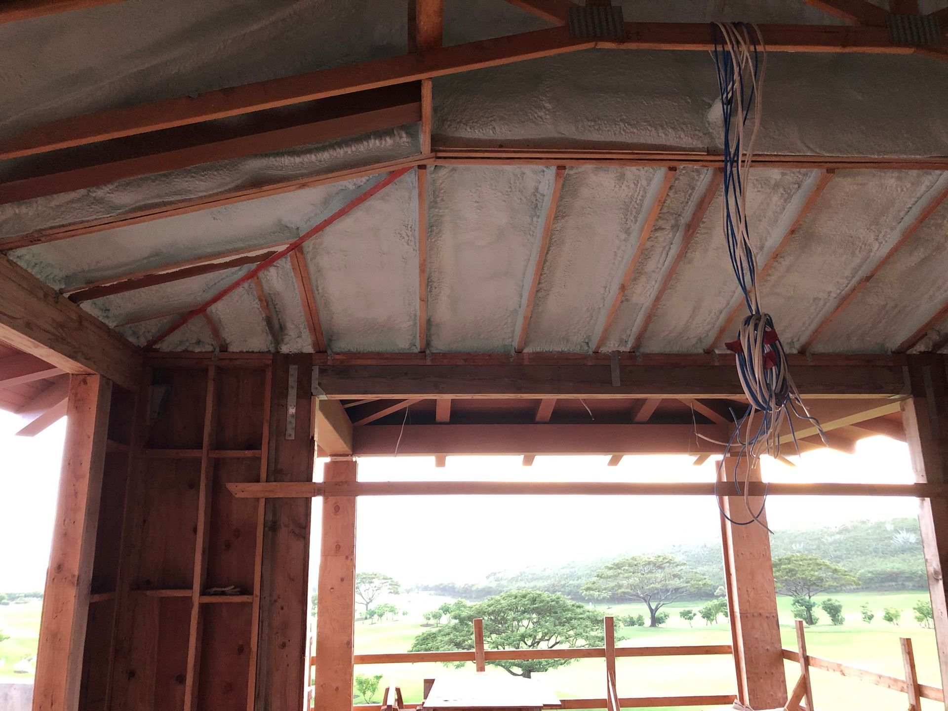 Interior view of a building under construction, showing wooden framework, insulation