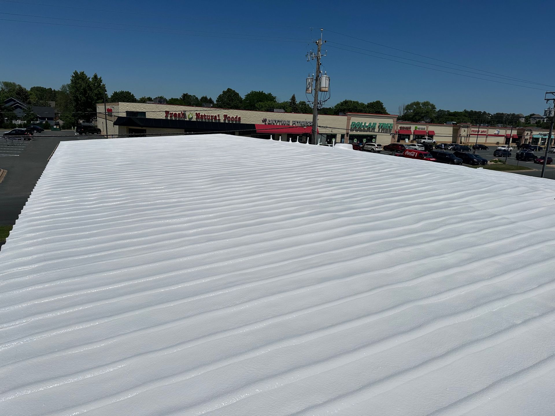 White corrugated metal roof on a commercial building on a sunny day.