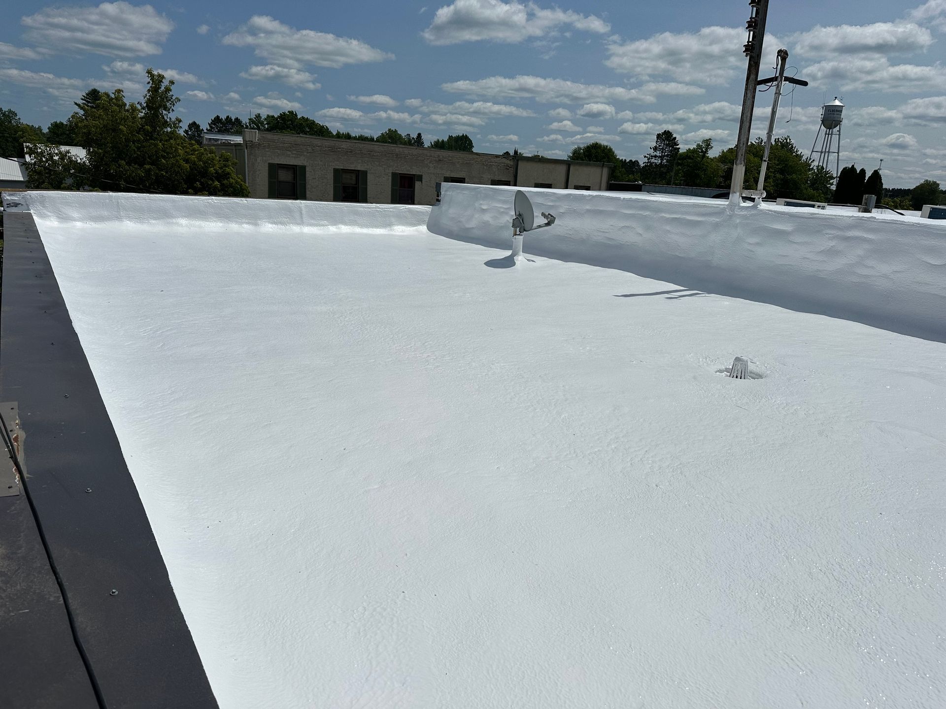 White commercial roof with a blue sky background.
