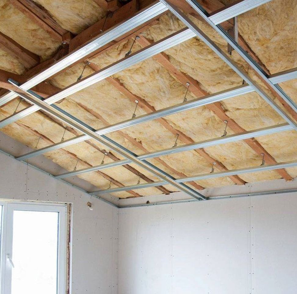 Interior view of a ceiling under construction with insulation, metal framing, and a partially built drywall.