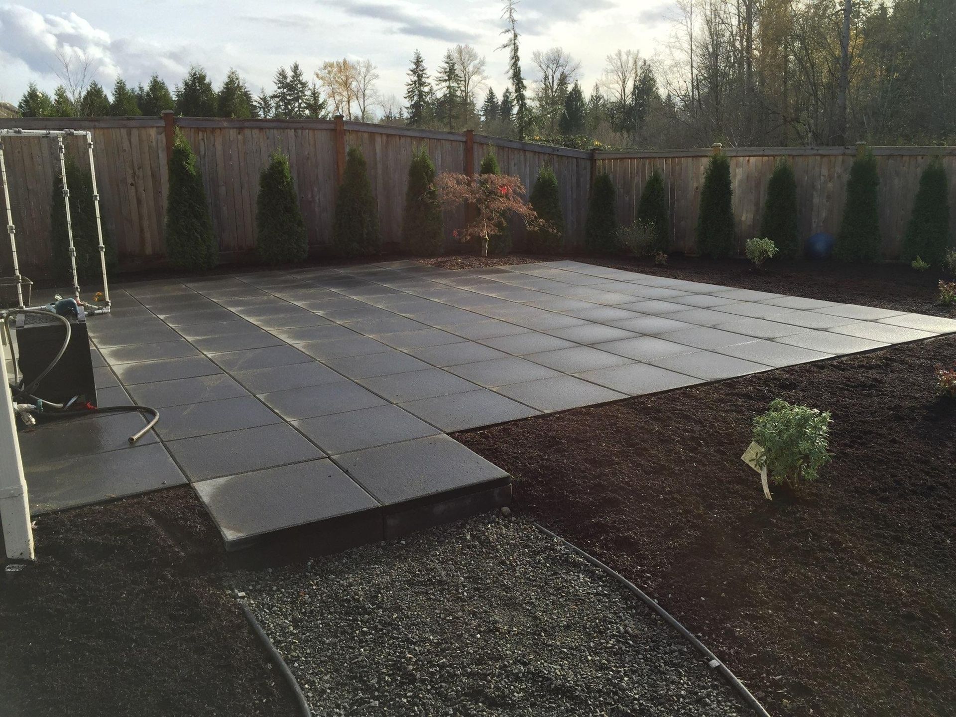 A fenced in backyard with a patio and trees in Monroe, WA.
