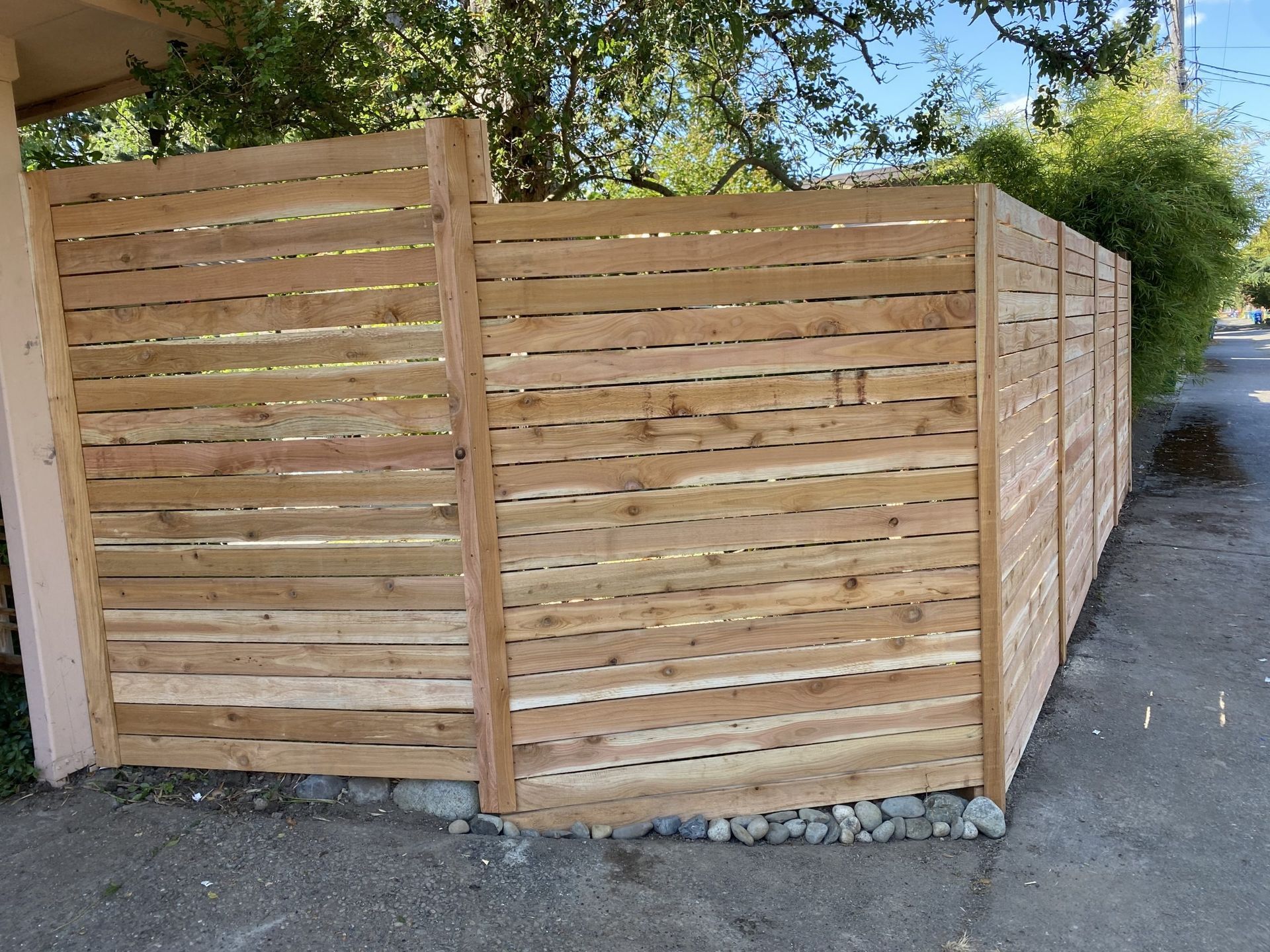 A wooden fence is sitting on the side of the road in Monroe, WA.