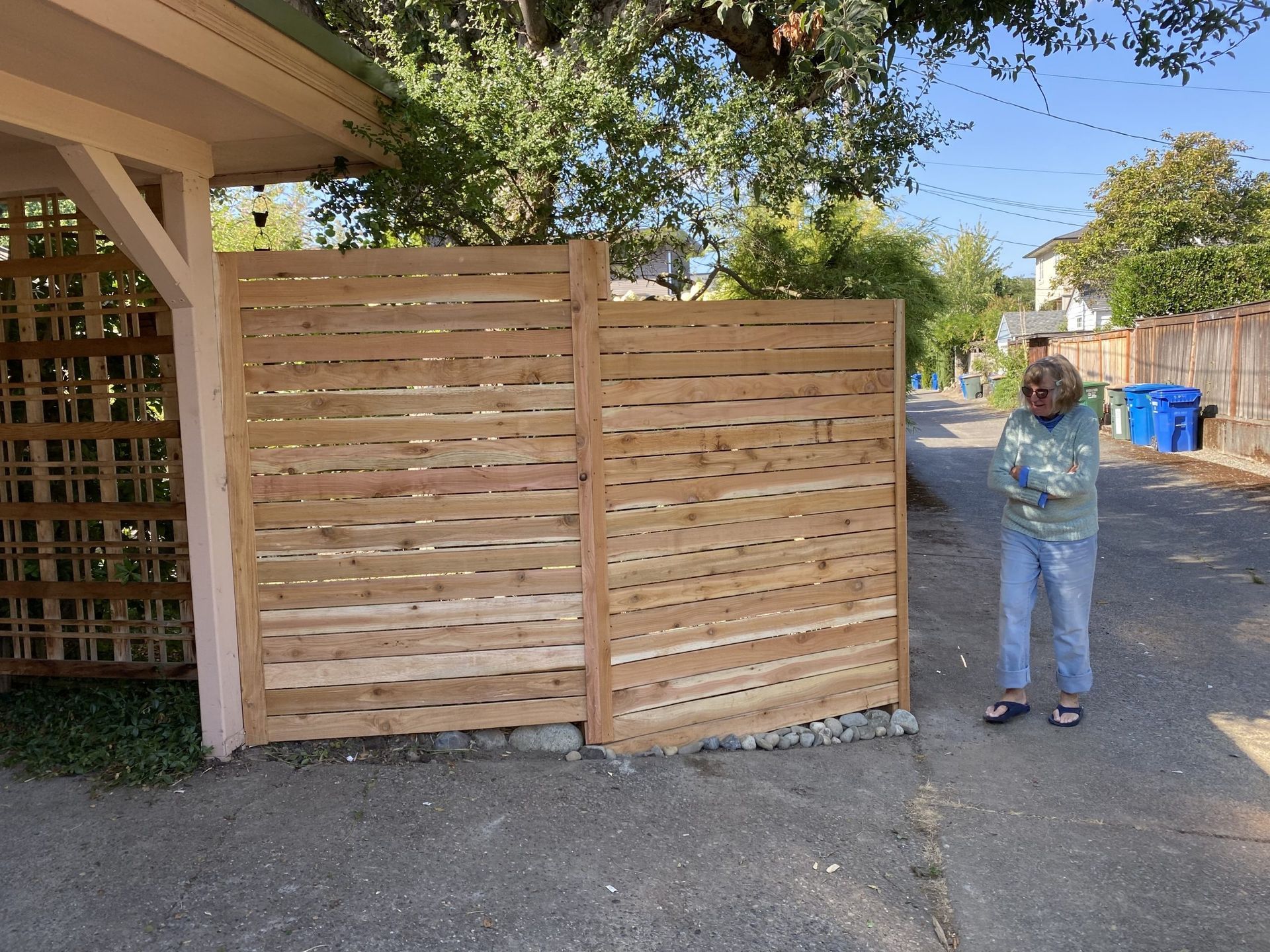 A man is standing in front of a wooden fence in Monroe, WA.