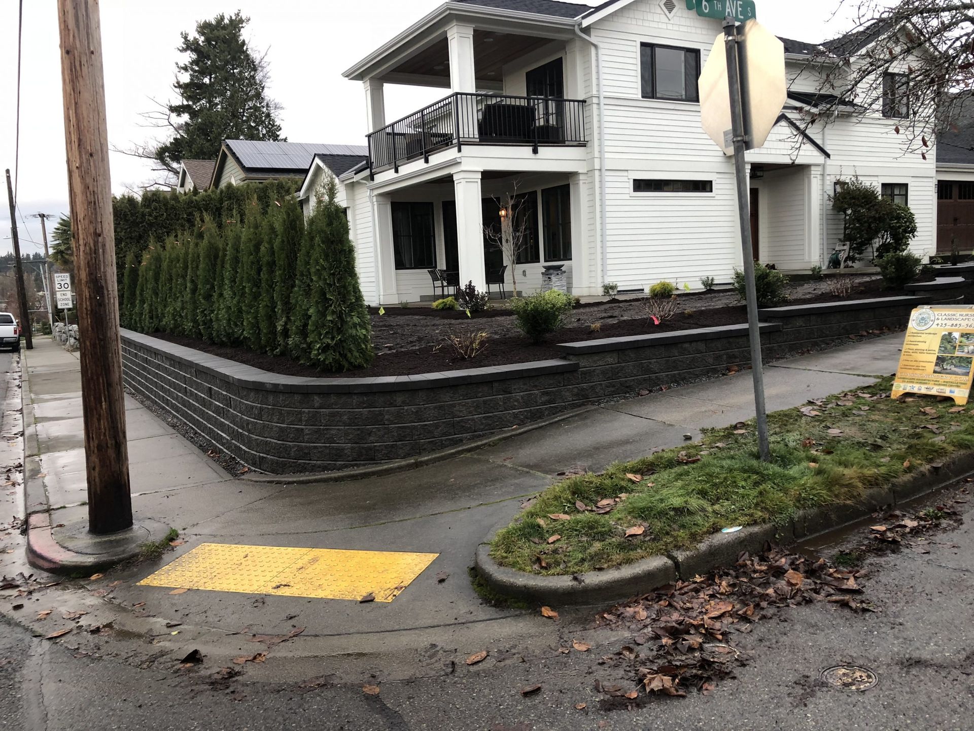 A corner of a street with a house in the background in Monroe, WA.