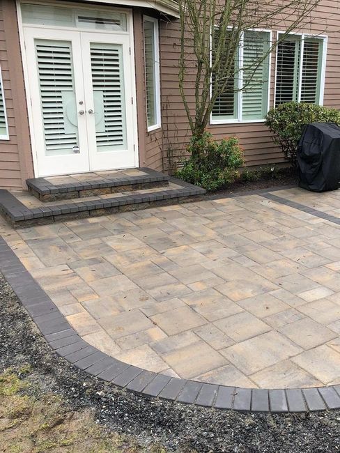 A patio in front of a house with steps and a grill cover in Monroe, WA.