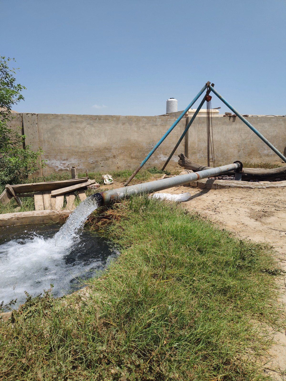 A wooden fence is sitting on top of a lush green field.