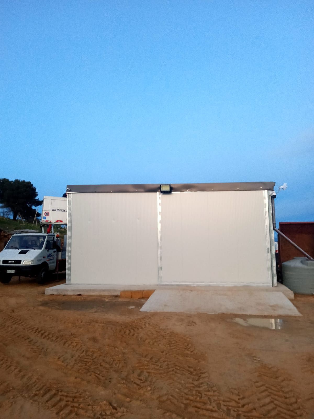 Un furgone bianco è parcheggiato davanti a un edificio bianco.