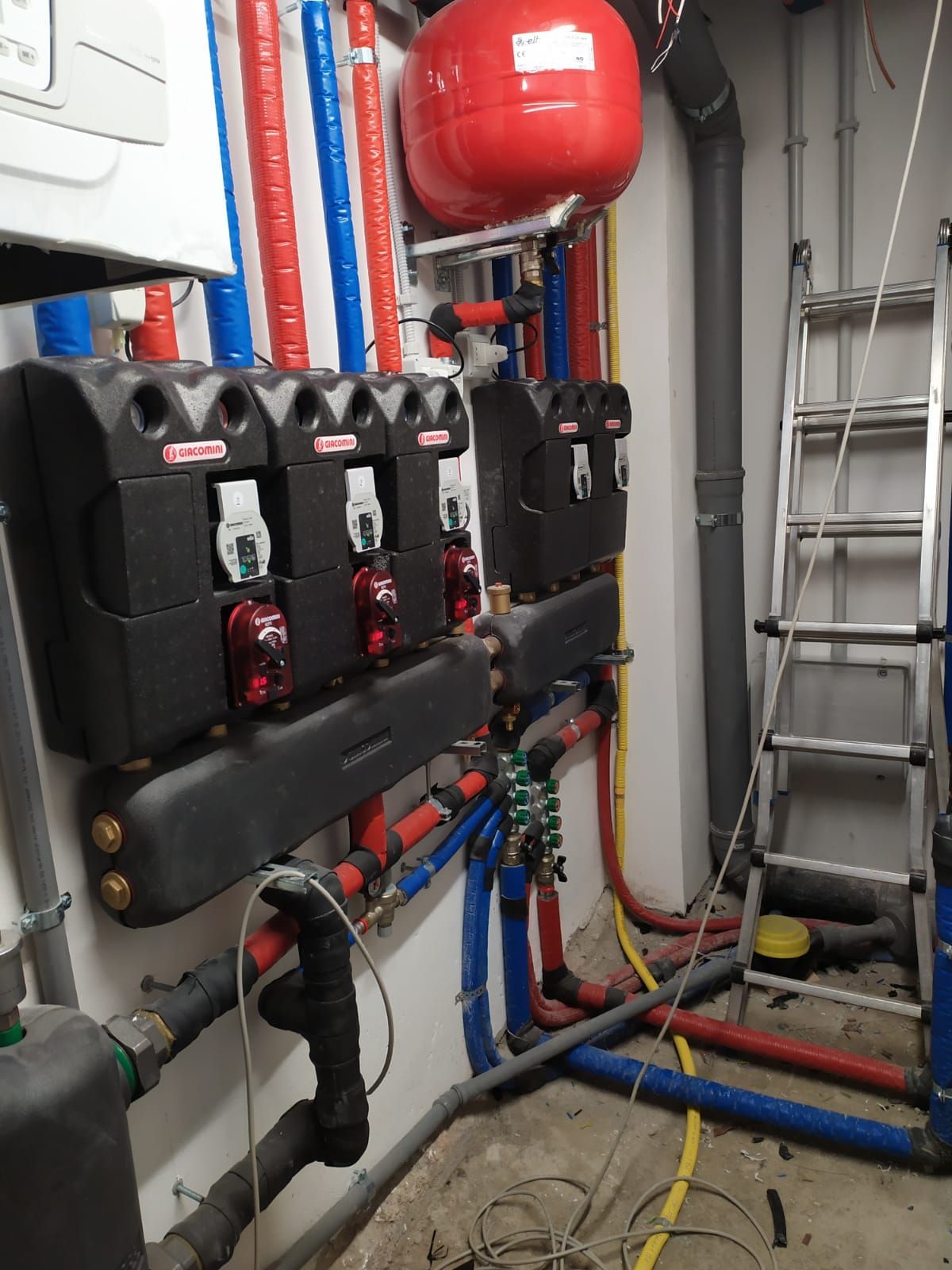 Una stanza con un sacco di tubi e una scala