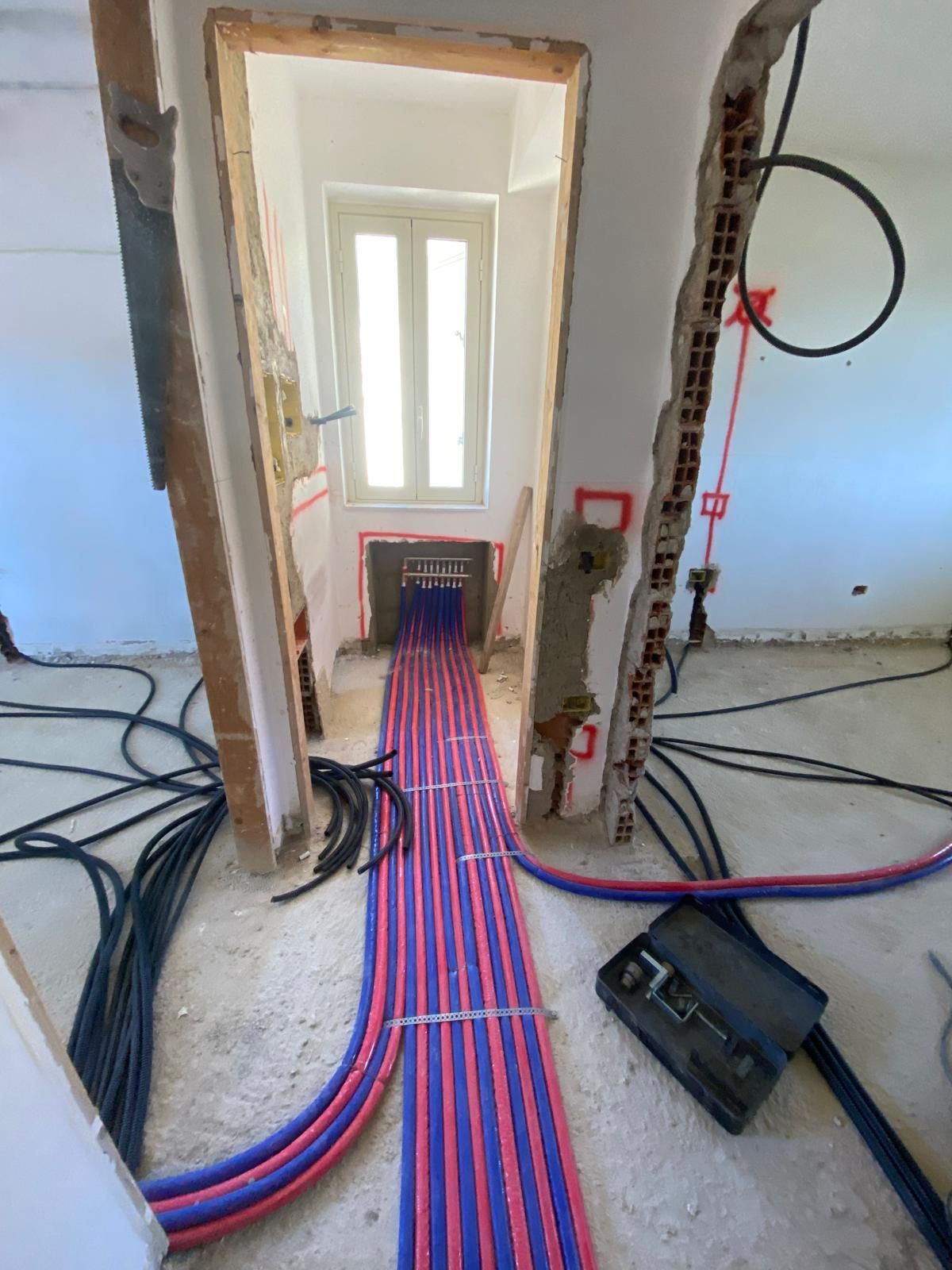 Un mucchio di fili sono collegati a una parete in una stanza.