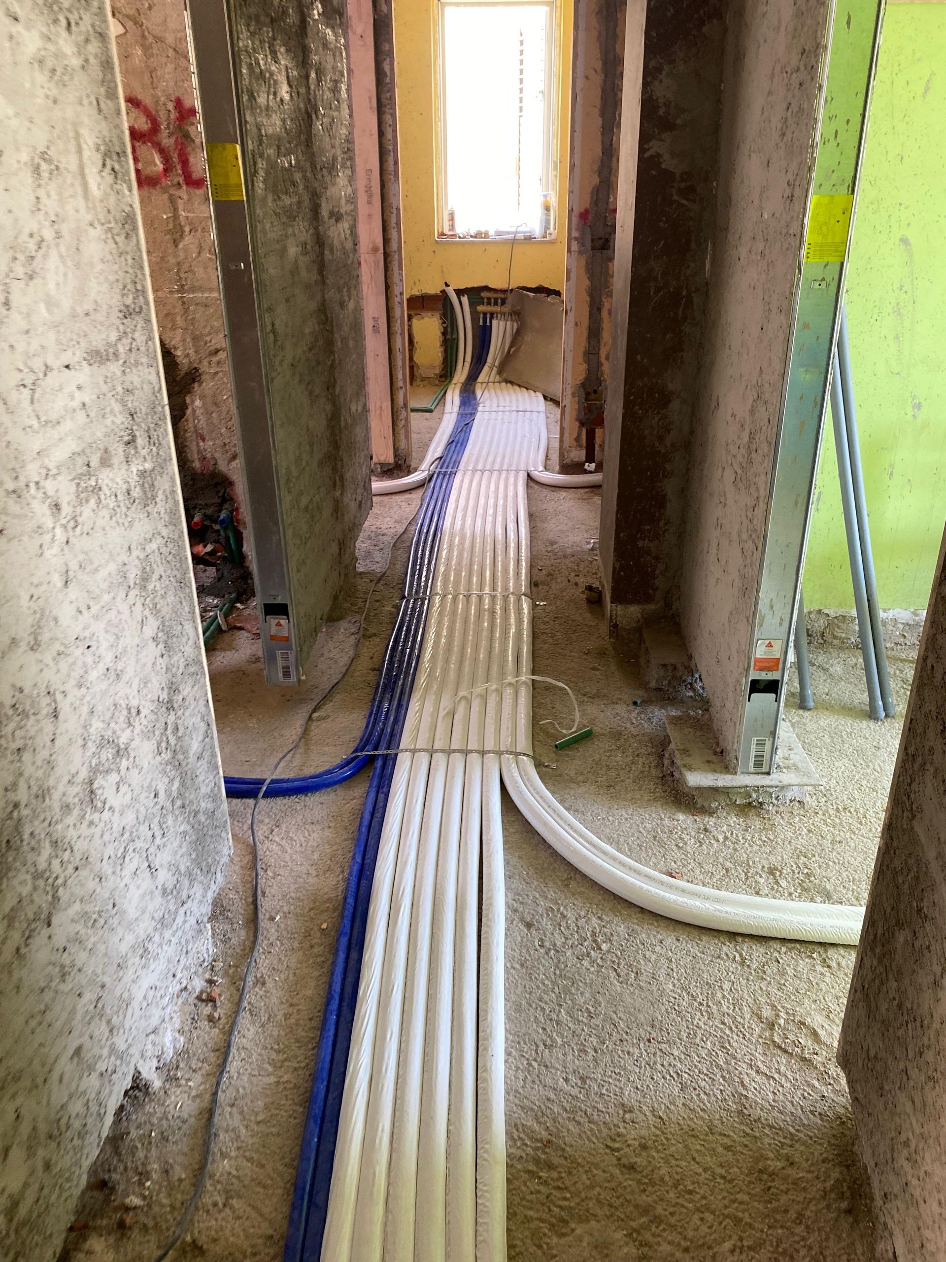 Un lungo corridoio attraversato da molti cavi.