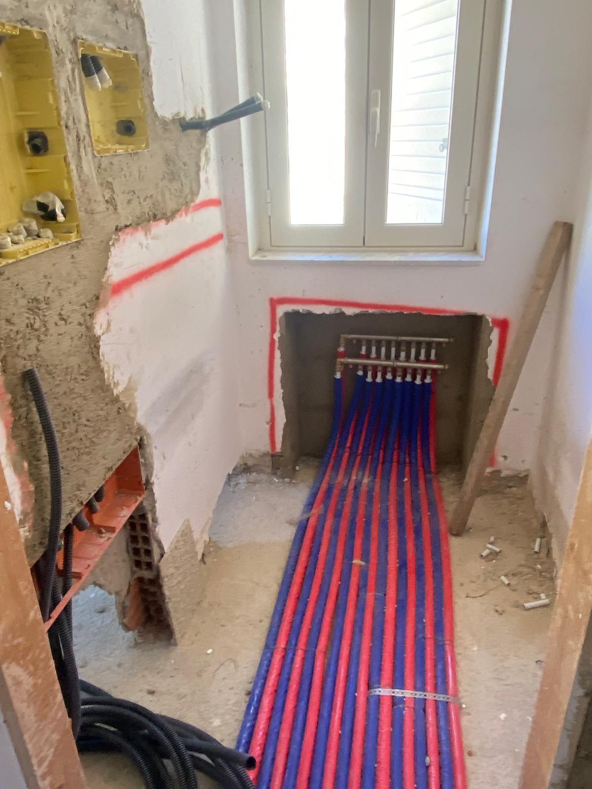 Una stanza con un sacco di tubi che escono dal muro.