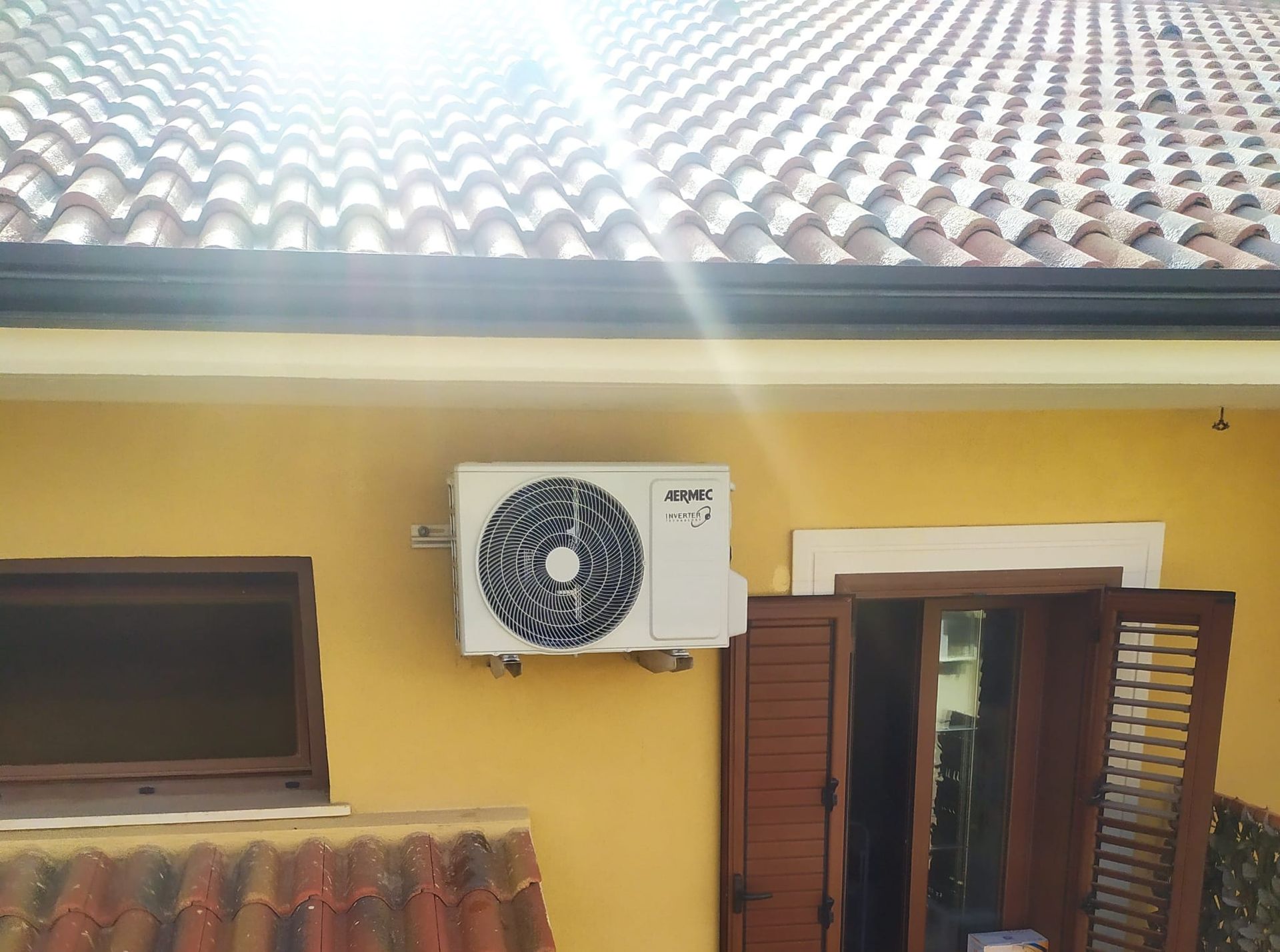 Un condizionatore d'aria bianco è montato sul lato di un edificio