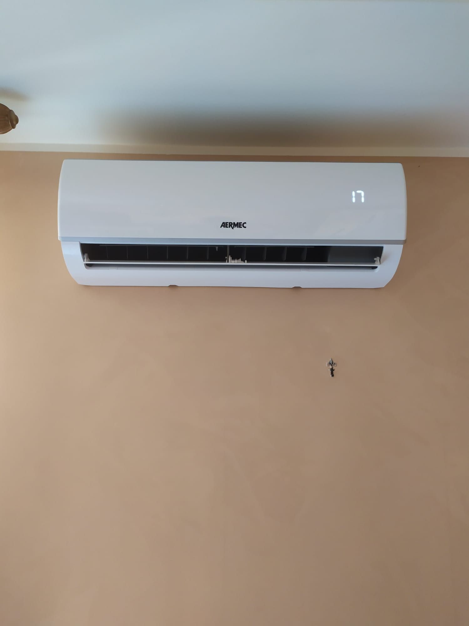 Un condizionatore bianco è appeso alla parete di una stanza.