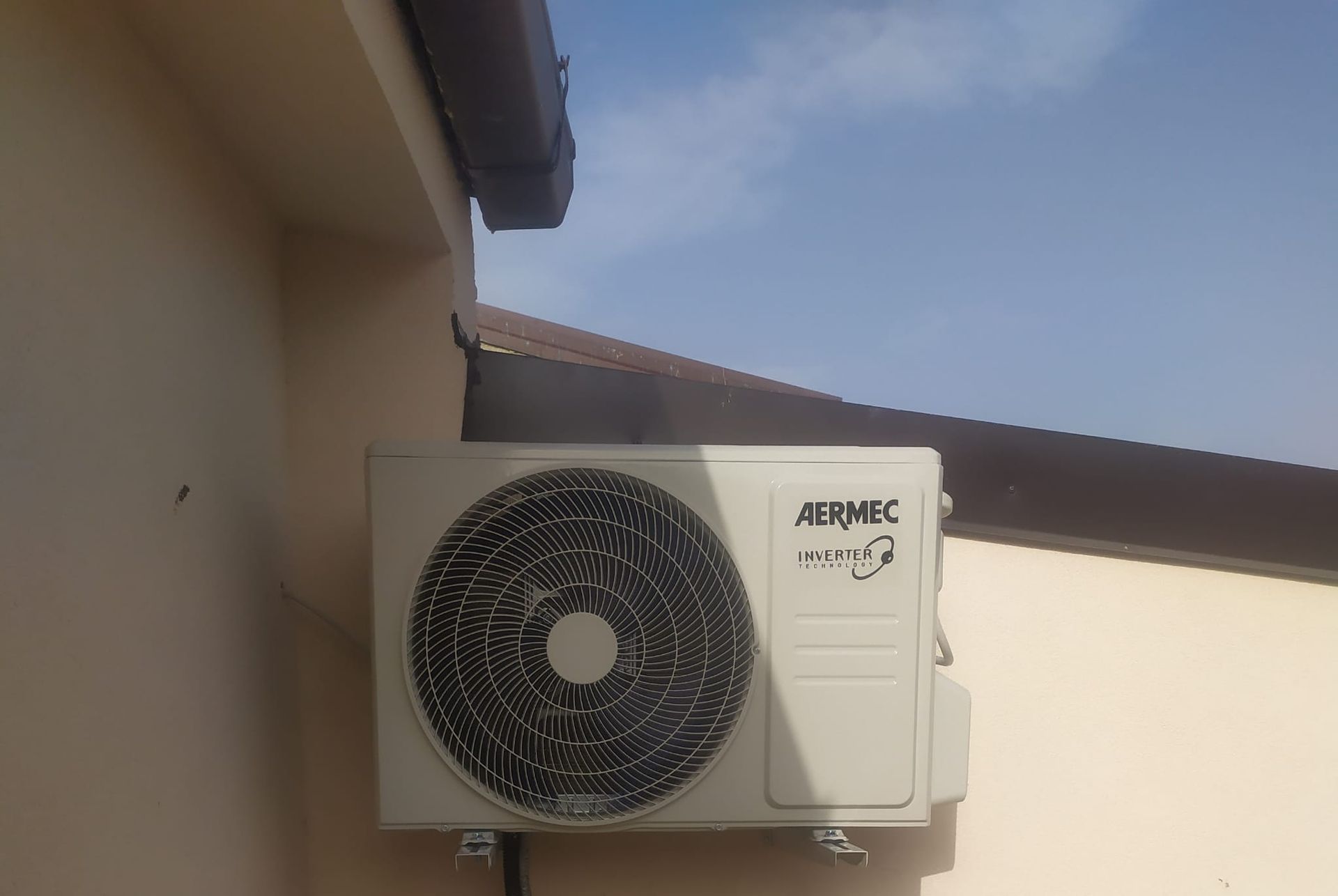 Un condizionatore bianco è montato sul lato di un edificio.