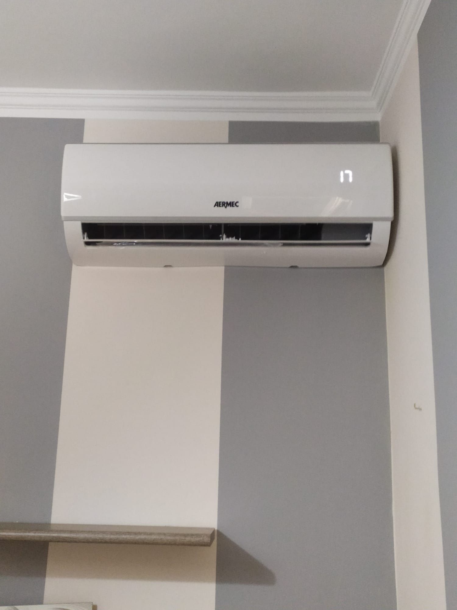 Un condizionatore bianco è appeso al soffitto di una stanza