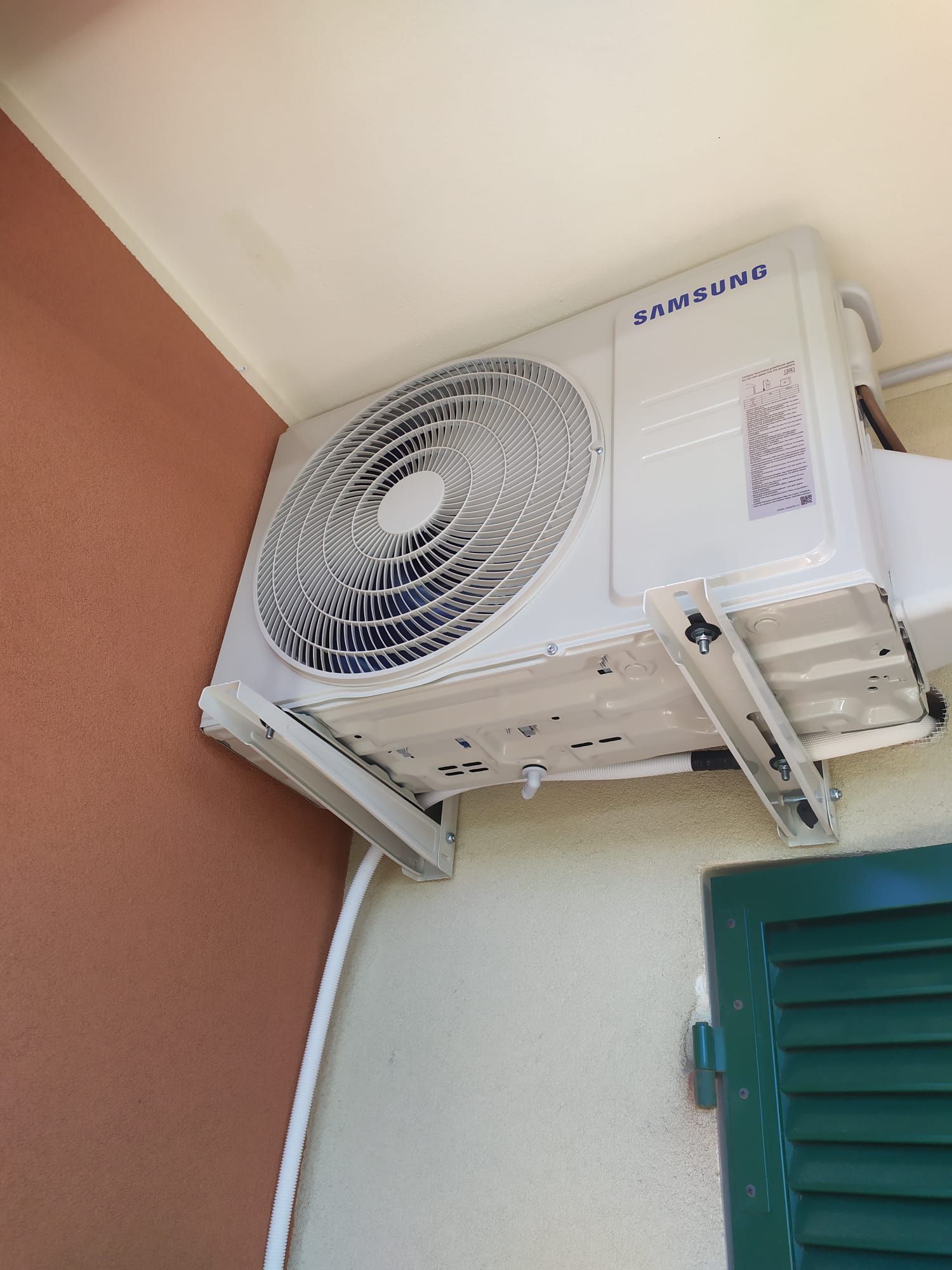 Un condizionatore d'aria Samsung è montato su una parete accanto a una finestra.