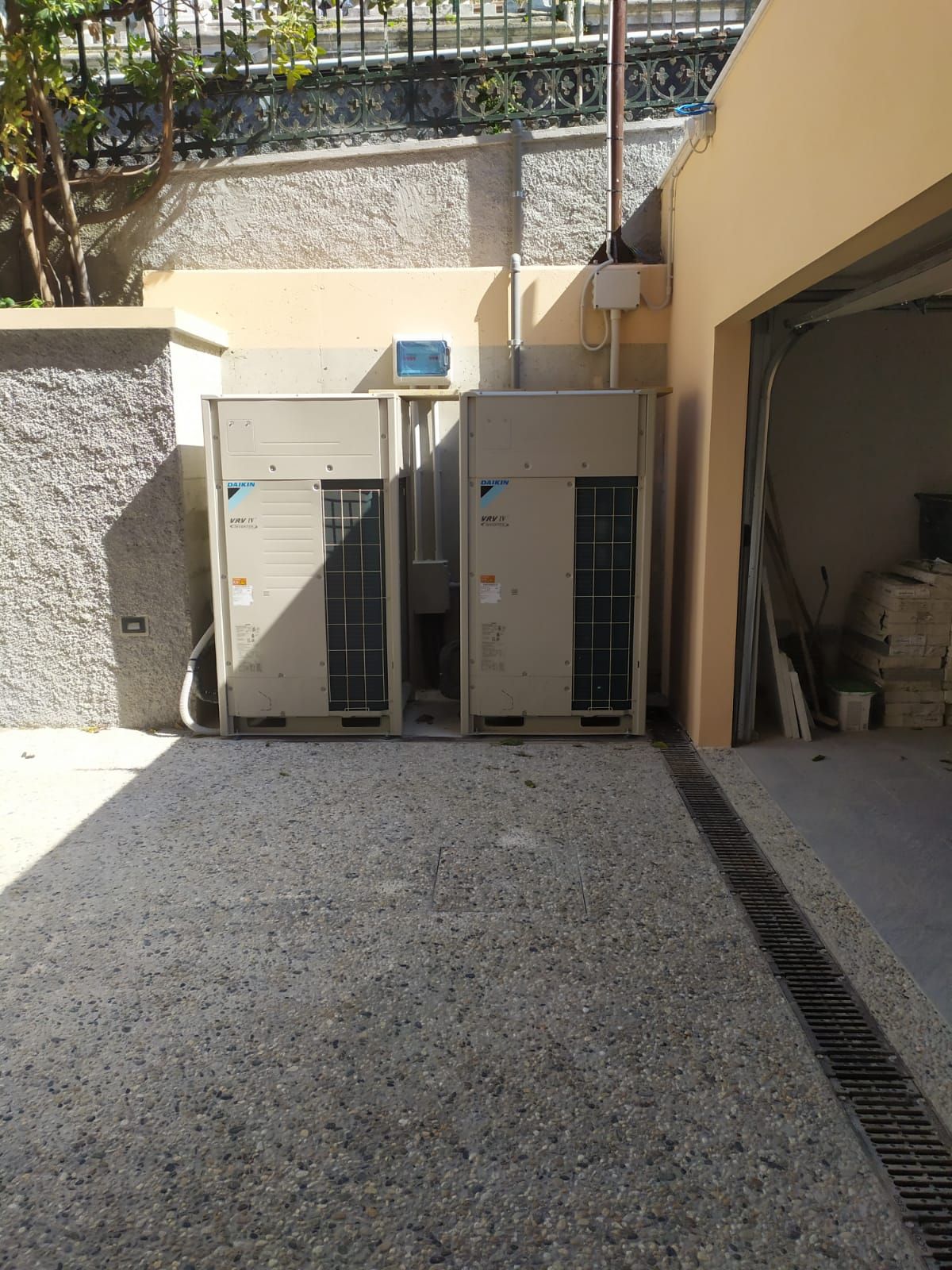 Due condizionatori d'aria sono posizionati fuori da un garage.