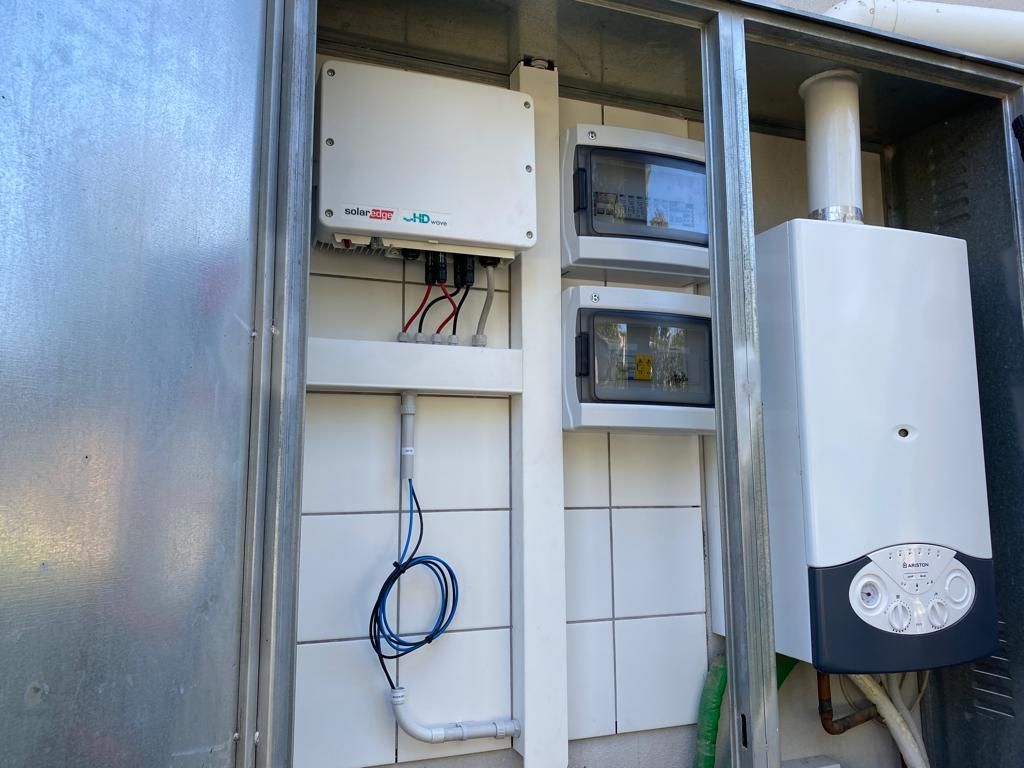 Una caldaia bianca è posizionata all'interno di una scatola di metallo.