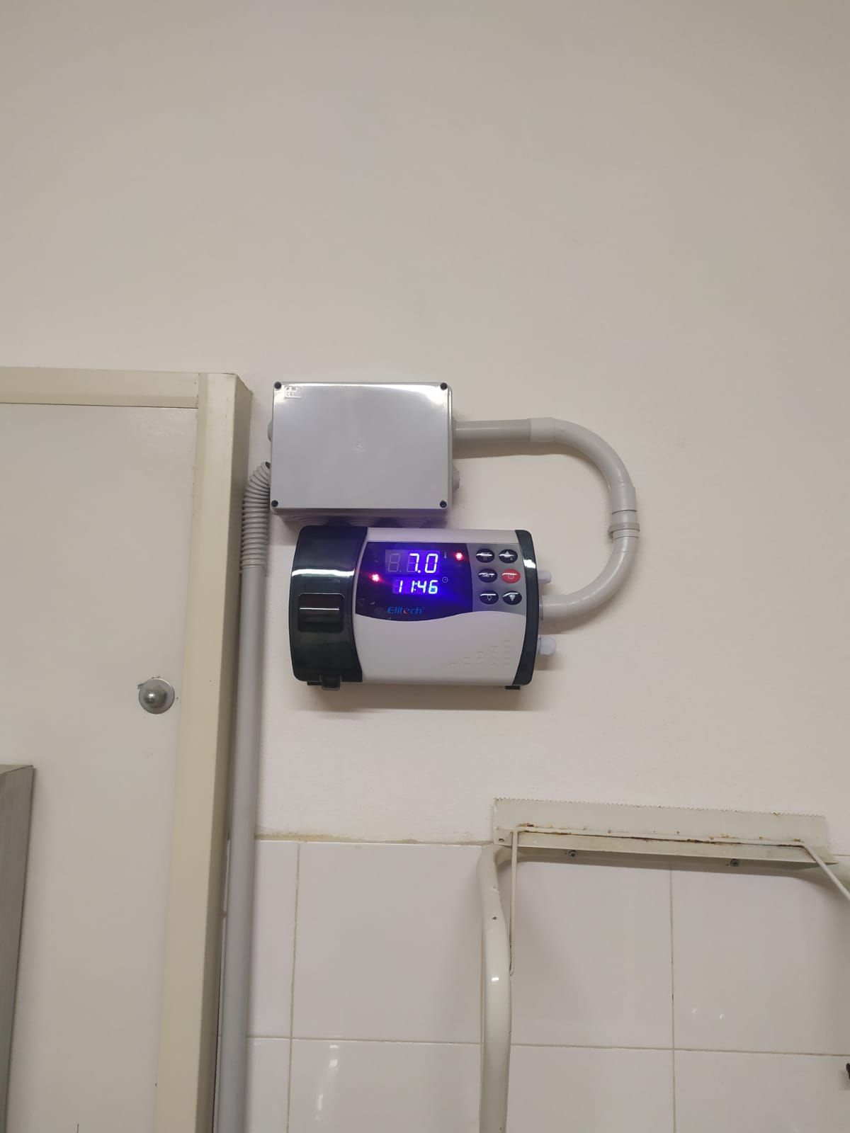 Un dispositivo è appeso a una parete accanto a una porta.