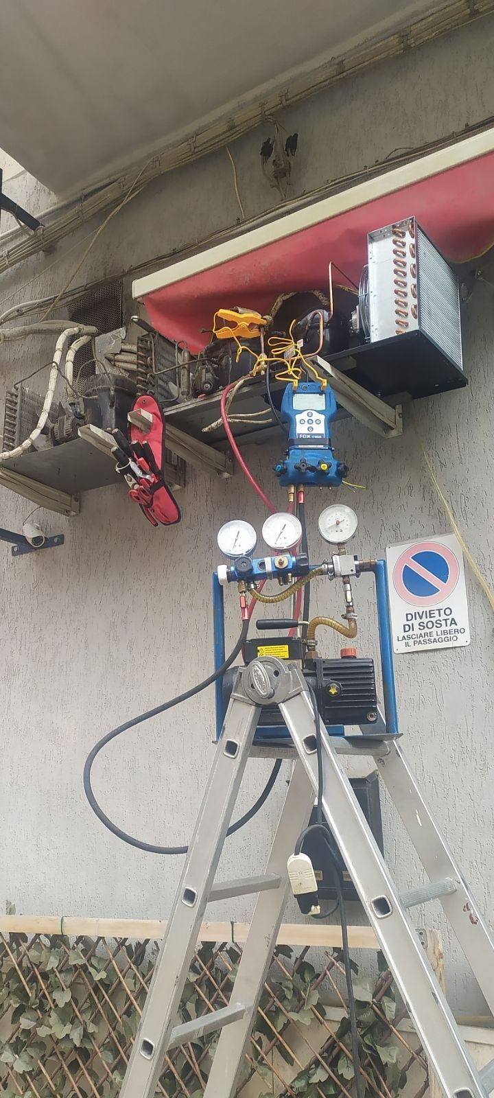 Una scala è appoggiata accanto a una macchina su un muro.