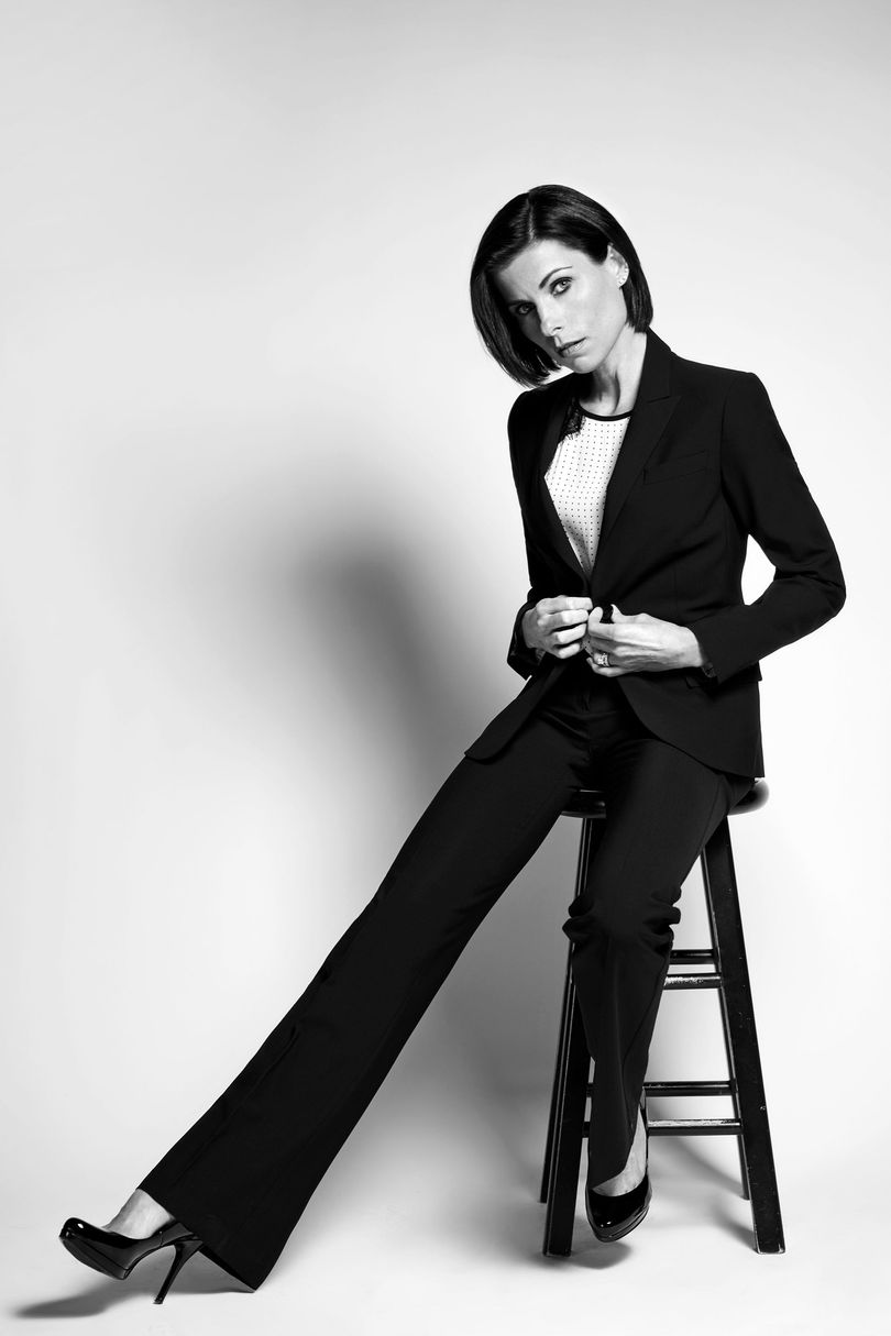 Nicky Tamberrino sitting on a stool in black suit in black and white