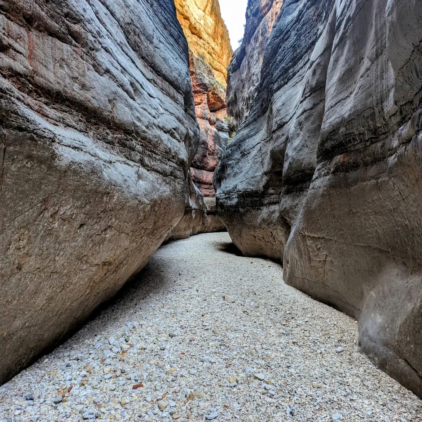 A narrow canyon filled with rocks and gravel.