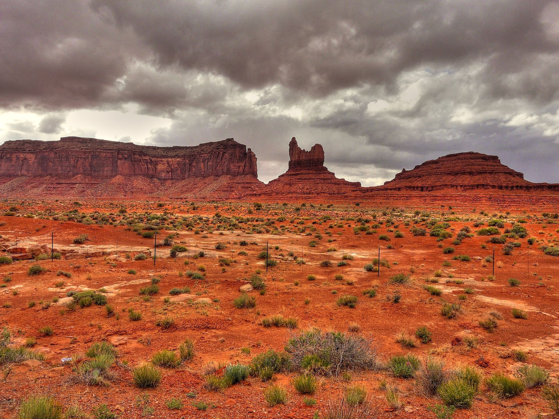 A desert landscape with mountains in the background and a cloudy sky