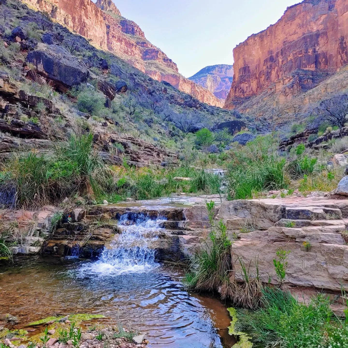 There is a small waterfall in the middle of a canyon.