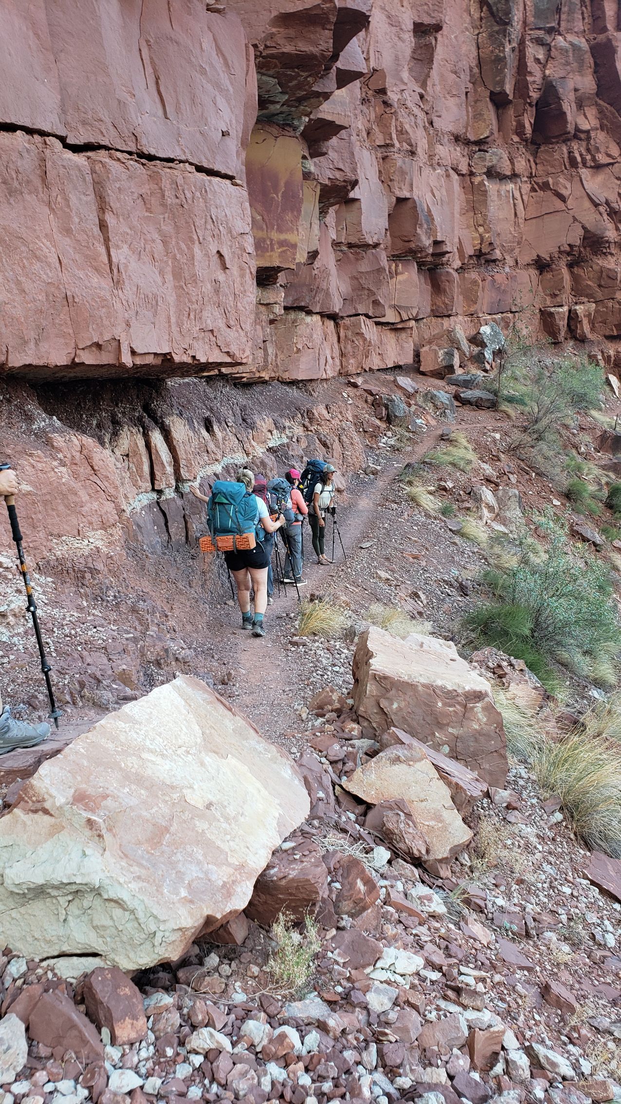 A group of people are hiking down a rocky trail.