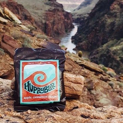 A bag of hoppybar sits on a rock in front of a river