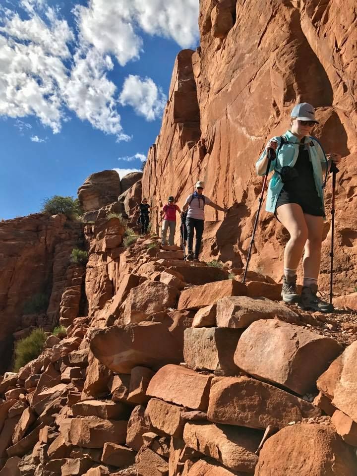 A group of people are hiking down a dirt path.