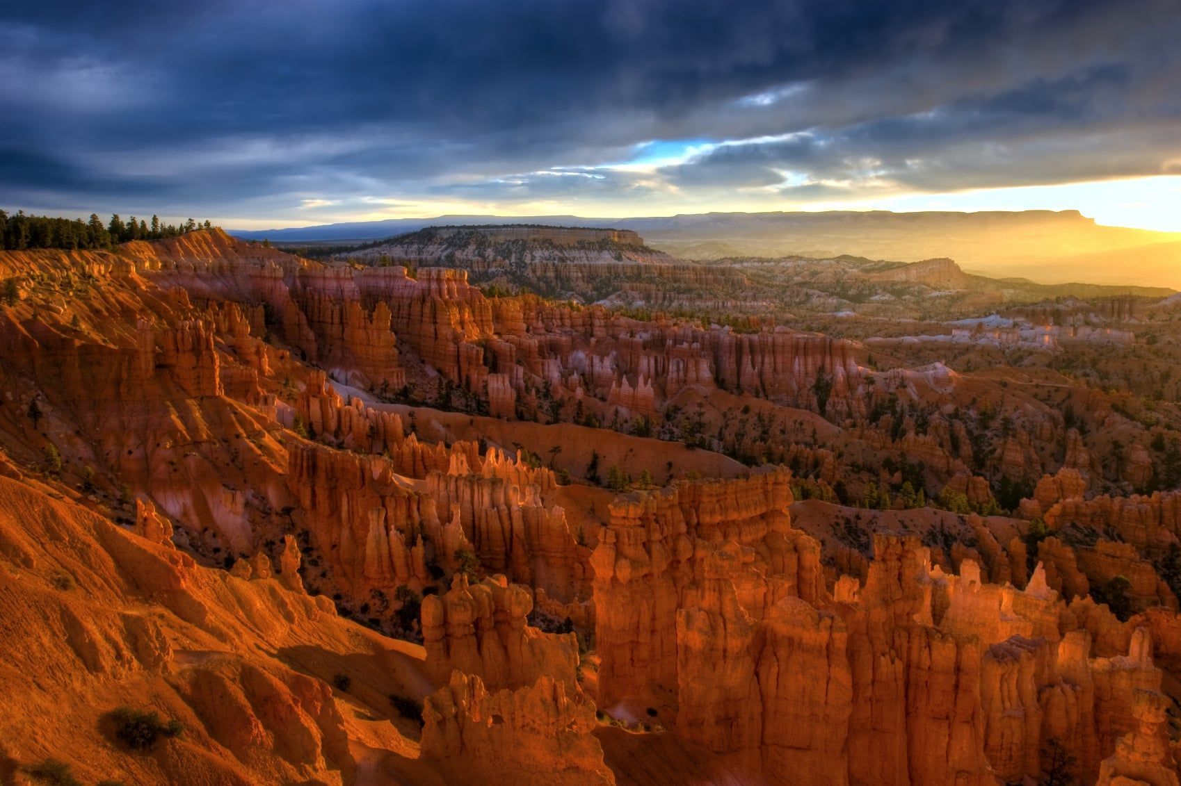 A view of a canyon at sunset with a cloudy sky.