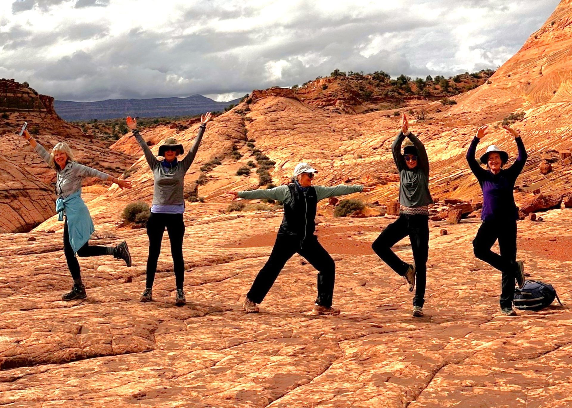 A group of women are posing for a picture in the desert.