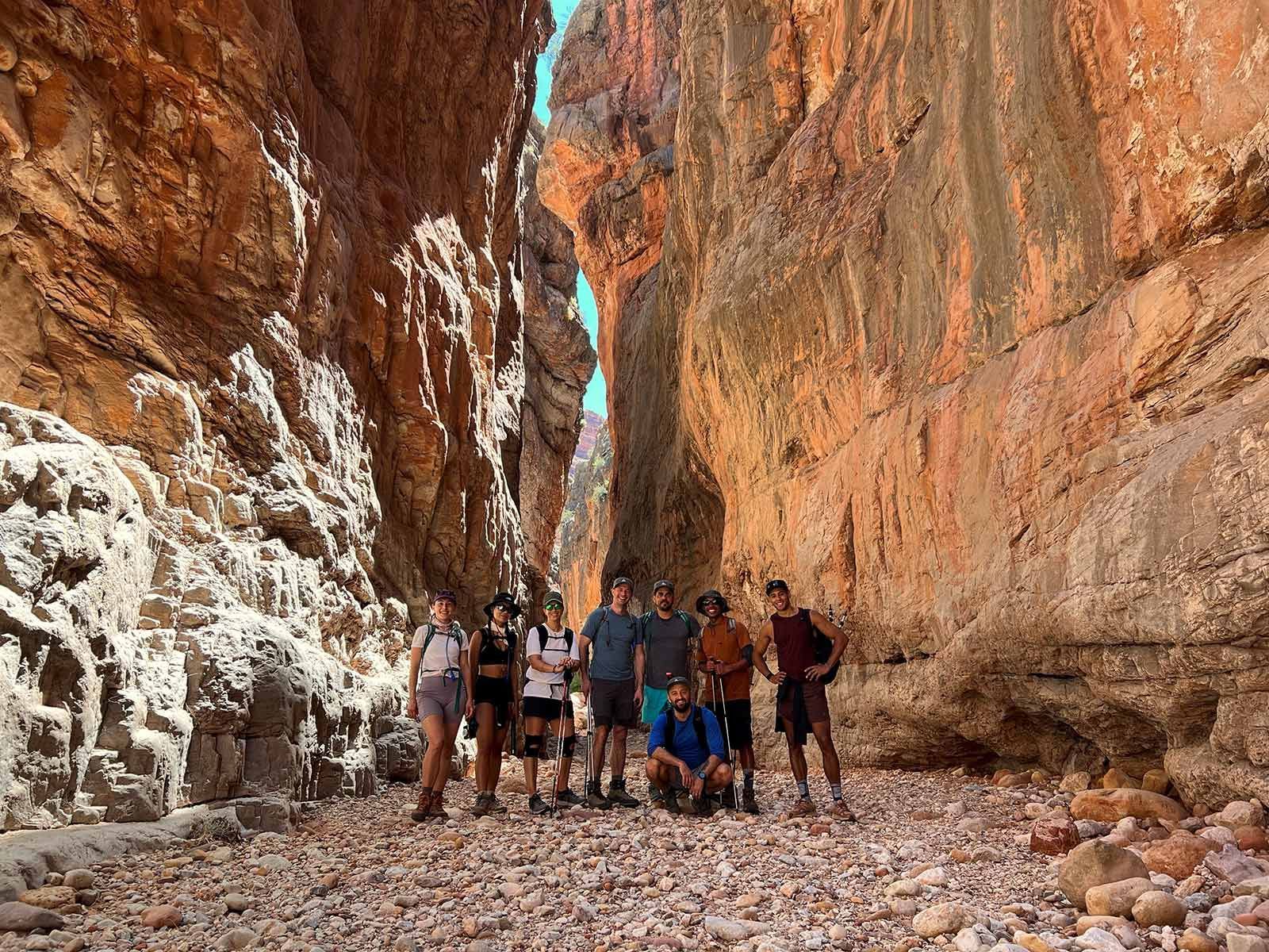 A group of people are posing for a picture in a canyon.