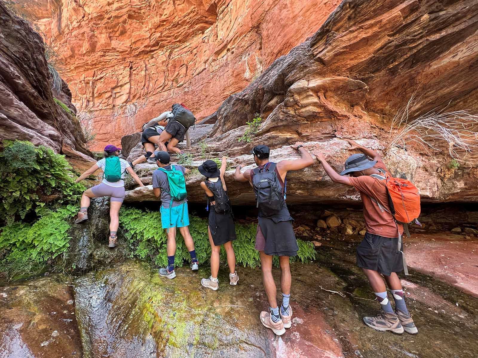 A group climbs up through a canyon